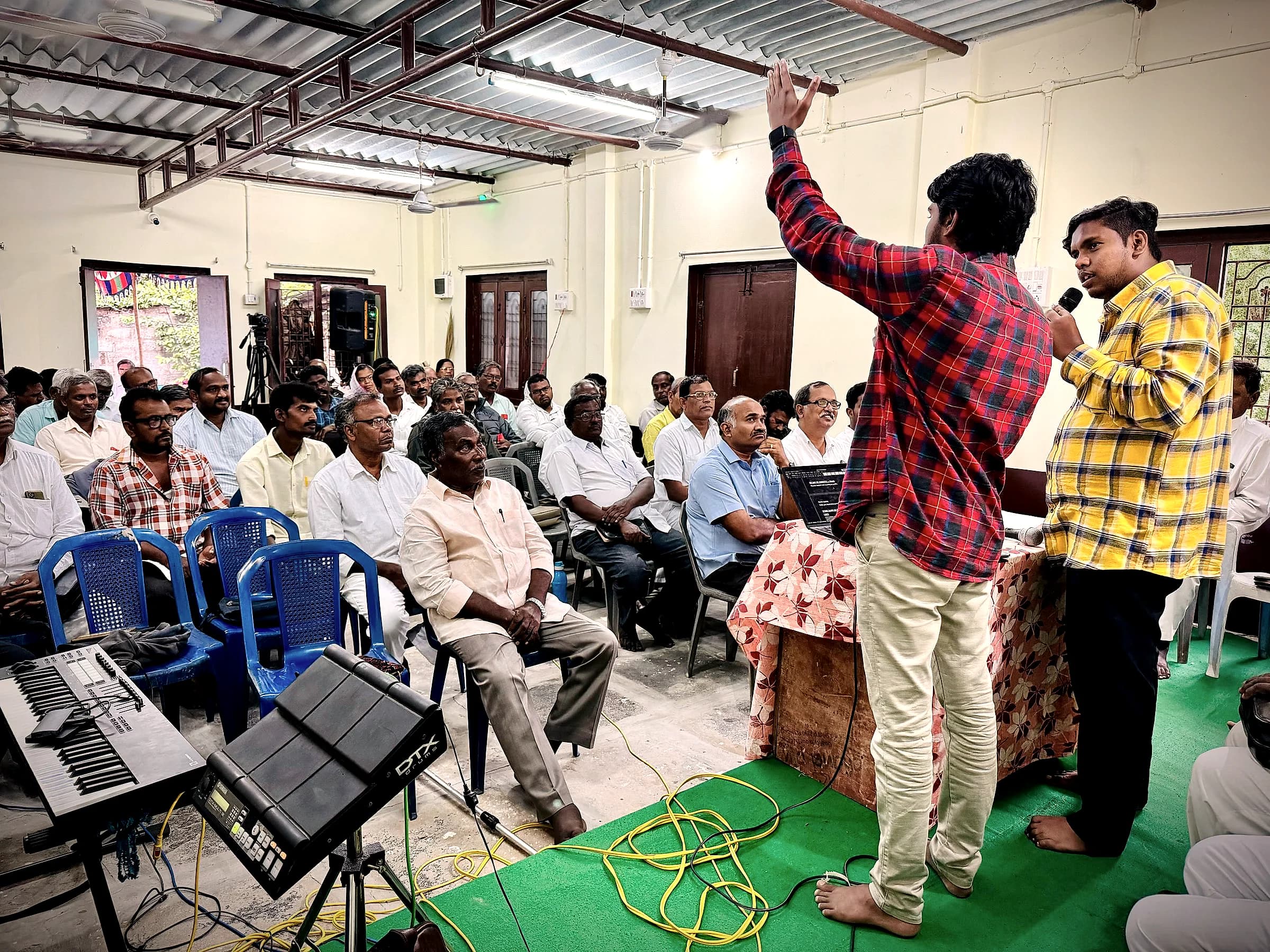 Two worship leaders singing to a seated congregation